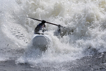 kayaking in the rapids in a river