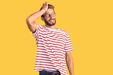 Handsome blond man with beard wearing casual clothes and glasses smiling confident touching hair with hand up gesture, posing attractive and fashionable