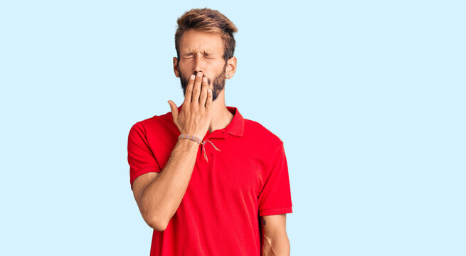 Handsome blond man with beard wearing casual clothes bored yawning tired covering mouth with hand. restless and sleepiness.