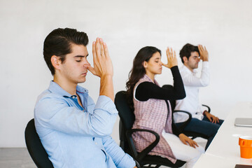 latin business people meditating and doing yoga in office in Mexico city
