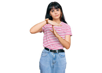 Young hispanic girl wearing casual clothes doing time out gesture with hands, frustrated and...