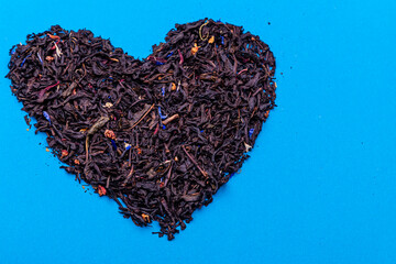 Organic dried tea leaves placed in a heart shape.