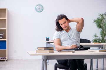 Young male student preparing for exam in the classroom