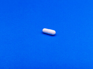 Pharmaceutical medicine pills, tablets and capsules on blue background. Top view. Flat lay. Copy space. Medicine concepts. Minimalistic abstract concept.