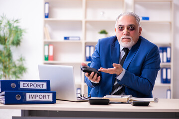 Old face injured employee sitting in the office