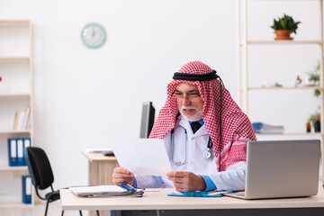 Old male arab doctor cardiologist working in the clinic