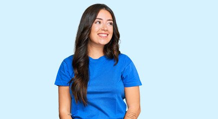 Fototapeta premium Beautiful brunette young woman wearing casual clothes looking away to side with smile on face, natural expression. laughing confident.
