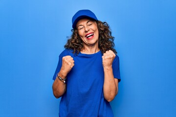 Middle age beautiful delivery woman wearing blue uniform and cap over isolated background celebrating surprised and amazed for success with arms raised and eyes closed