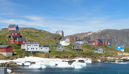 Greenland village with colorful homes on the water with icebergs. © ChristyLangPhotos