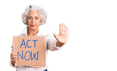 Senior grey-haired woman holding act now banner with open hand doing stop sign with serious and...