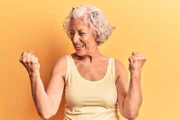 Senior grey-haired woman wearing casual clothes very happy and excited doing winner gesture with arms raised, smiling and screaming for success. celebration concept.