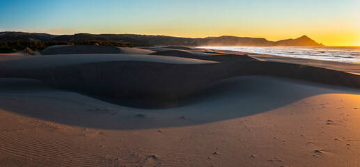 An amazing sea view during sunset time of an awe sandy beach full of sand dunes till the infinite. Idyllic natural landscape for going back to nature and enjoy the outdoors again