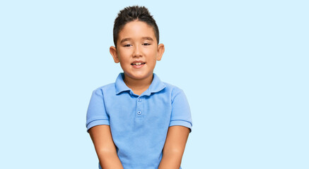 Little boy hispanic kid wearing casual clothes with hands together and crossed fingers smiling relaxed and cheerful. success and optimistic