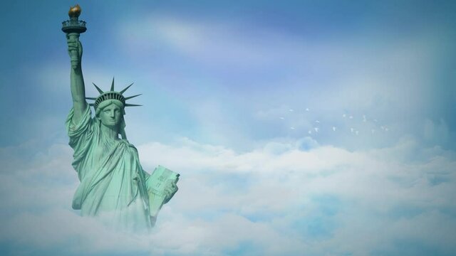 Statue of Liberty Above the Clouds 4K Loop features the Statue of Liberty with the top half above clouds that are moving by with a blue sky in the background in a loop