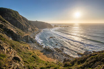 An awe sunset in an idyllic beach landscape with the sunset over the water and the sunlight...
