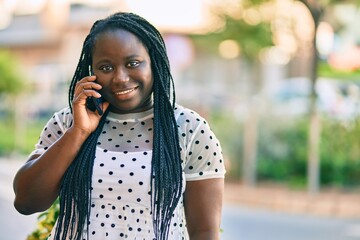 Young african american woman smiling happy talking on the smartphone at the city.