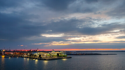 Sunrise on an early morning on the Baltic coast of Helsinki Finland with the cruise ship port in view from the sea.