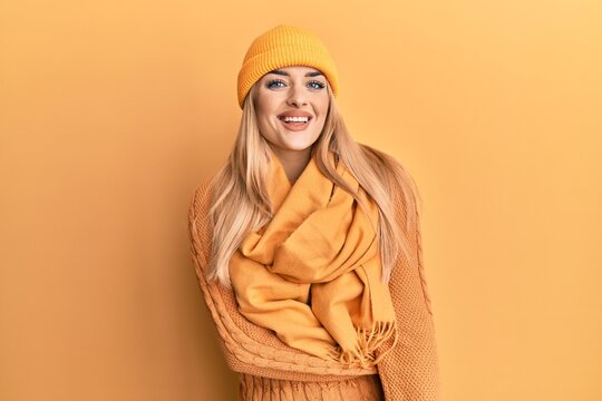 Young caucasian woman wearing wool winter sweater and cap with a happy and cool smile on face. lucky person.