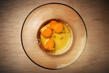 Close-up of raw egg yolks in a glass plate