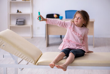 Fototapeta premium Small girl holding syringe waiting for doctor in the clinic