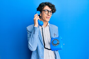 Hispanic young man speaking on vintage telephone winking looking at the camera with sexy...