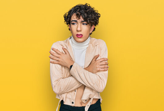 Handsome man wearing make up and woman clothes shaking and freezing for winter cold with sad and shock expression on face