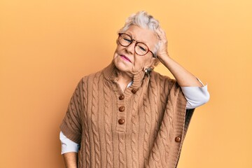 Senior grey-haired woman wearing casual clothes and glasses confuse and wonder about question. uncertain with doubt, thinking with hand on head. pensive concept.