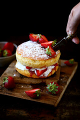 Soft focus. Victoria sponge cake. The famous dessert biscuit with strawberries.