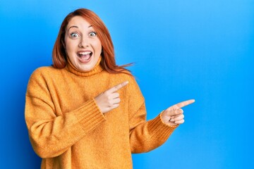 Beautiful redhead woman pointing fingers to the side celebrating crazy and amazed for success with...