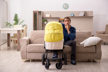 Young male contractor looking after baby at home