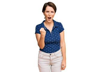 Young brunette woman with short hair wearing casual clothes angry and mad raising fist frustrated and furious while shouting with anger. rage and aggressive concept.
