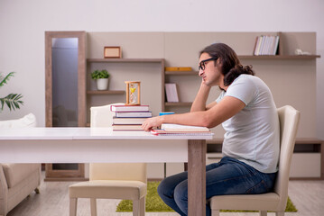 Young male student preparing for exams at home