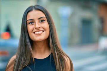 Young hispanic girl smiling happy standing at the city.