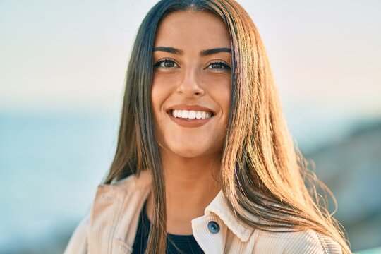 Young hispanic girl smiling happy standing at the promenade.