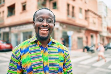 Obraz premium Young african american man smiling happy standing at street of city.