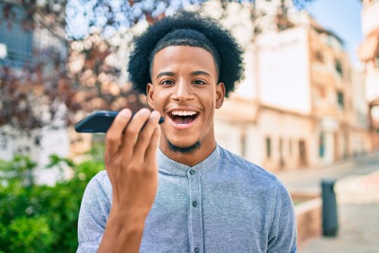 Young african american man smiling happy sending audio message using smartphone at the city.