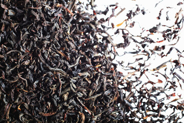 Closeup of dried black tea leaves on white background