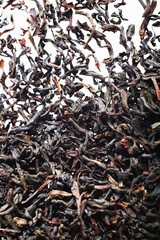 Closeup of dried black tea leaves on white background