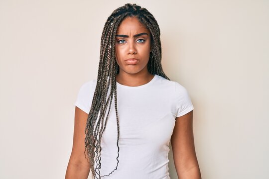 Young african american woman with braids wearing casual white tshirt depressed and worry for distress, crying angry and afraid. sad expression.