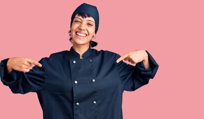 Young brunette woman with short hair wearing professional cook uniform looking confident with smile...