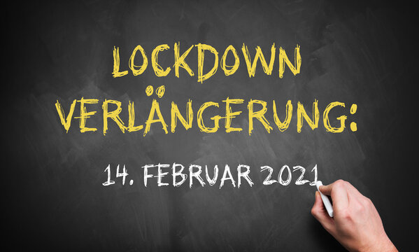 hand writing on a blackboard the German message for LOCKDOWN EXTENDED UNITL 14th OF FEBRUARY 2021