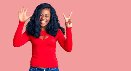Beautiful african american woman wearing casual clothes showing and pointing up with fingers number...