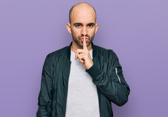 Young hispanic man wearing casual clothes asking to be quiet with finger on lips. silence and...