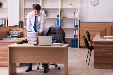 Young male employee unhappy with excessive work in the office