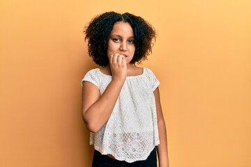 Young little girl with afro hair wearing casual clothes looking stressed and nervous with hands on mouth biting nails. anxiety problem.