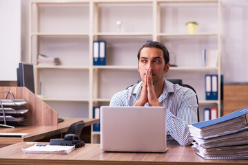 Fototapeta premium Young male employee working in the office
