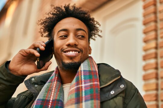 Young african american man smiling happy talking on the smartphone at the city