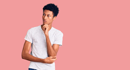 Young african american man wearing casual white t shirt serious face thinking about question with...