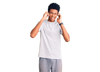 Young african american man wearing casual clothes covering ears with fingers with annoyed expression for the noise of loud music. deaf concept.