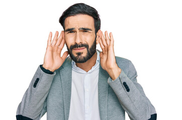 Young hispanic man wearing business clothes trying to hear both hands on ear gesture, curious for gossip. hearing problem, deaf